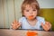 Baby toddler eats carrots with bare hands