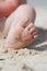 Baby toddler feet with sand on sunny beach