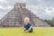 Baby traveler, tourists observing the old pyramid and temple of the castle of the Mayan architecture known as Chichen