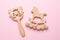 Baby wooden rattles and toys on pink background isolated