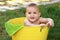 Baby in yellow bucket in garden