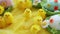 Baby yellow Easter toys chicks and eggs on a background of feathers. Festive video greeting card.