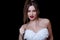 Babyface female model wearing strapless white dress on black background