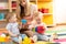 Babysitter and children play together in nursery or day care centre