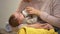 Babysitter feeding cute little child from bottle, artificial feeding accessories