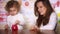 Babysitter and little cute child girl putting coins into piggy bank