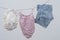 Babyâ€™s beach clothes drying on a clothesline. Tiny white Panama hat, pink bikini and striped shorts on white background.