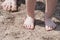 Babyâ€™s and manâ€™s feet on a sandy beach. Close up. Summer vibes. Sunbathing after swimming.