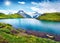 Bachalpsee lake in the morning mist with Schreckhorn peak on background. Green summer scene of Swiss Bernese Alps, Switzerland, Eu