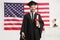 Bachelor graduate student posing in front of a USA flag