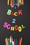 Back 2 school colorful letters and stationery on blackboard background with copyspace for your text. Concept for your