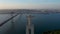 Back aerial view of Sanctuary of Christ the King statue with Ponte 25 de Abril red bridge in Lisbon, Portugal