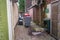 A back alley or alley way with skips and rubbish thrown in it in St Helens, Merseyside