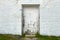 Back alley boarded up doorway whitewashed brick building alley grass