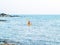 Back of Asian woman in life jacket and cap kayaking on yellow kayak boat with using paddle on the sea.