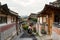 Back of Asian woman wearing hanbok walking through the Seoul traditional style houses of Bukchon Hanok Village in Seoul, South Ko