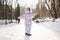 Back of baby girl wear child snowsuit on a sunny frosty winter day