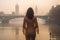 Back beautiful slim chic girl with long brunette hair in foggy weather against the background London bridge. Generative AI