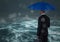 Back of business man with umbrella against stormy sea with bokeh