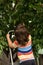 Back of child boy picking cherries