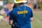 Back of a coach`s blue color shirt with the word Coach in yellow