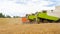 Back of combine harvester and truck on wheat field