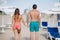Back couple walking on the beach. On the back of a man and on the woman`s buttocks is handprint of sand