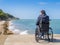 Back of disabled man in wheelchair at beach