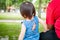 Back father and little daughter enjoy park view in a tropical park, sitting on a bench. Children and dad together outdoor