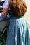 Back of female with long red hair in German style dress