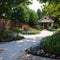 Back and front yard cottage garden, flowering plant and green grass lawn, brown pavement and orange brick