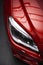 Back headlight of a modern luxury red car, auto detail, car care concept in the garage