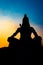 Back lit statue of hindu god lord shiva in meditation posture with dramatic sky from unique angle