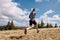 back male runner cross country running on dry grass