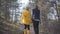 Back of man and woman holding hands walking in the spring forest