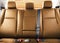 Back passenger brown leather seats in modern luxury car. Orange perforated leather with stitching. Car inside. Leather comfortable