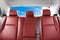 Back passenger red leather seats in modern luxury car. Red perforated leather with stitching. Car inside. Leather comfortable red