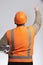 Back of plupm construction worker in hard hat and reflective vest on studio background showing with hand direction forward,