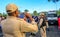 Back of the policeman taking pictures of costume people at Bloco Orquestra Voadora in Flamengo Park, Carnaval 2017