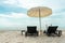 Back portrait of little girl lying on the beach bench and showing her fingers in victory sign with horizontal skyline of ocean