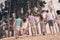 Back rear view full length photo of young fellow hold hands walk sand countryside rest weekend outdoors