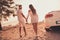 Back rear view full size photo of husband wife hold hands walk beach support romance cabriolet outdoors