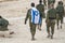 Back shot of several soldiers of israel army walking with israel national flag. Military man bearing israel flag on his shoulder