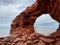 Back shot of a woman standing on rocks under the sea cliffs at Cavendish Beach, Prince Edward Island