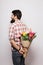 Back side of Handsome young man with beard and nice bouquet of flowers