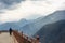 Back side of one man walk on bridge by the side of range green high mountain in Lijiang ,China