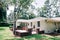 Back side Rearview of exterior white cream brick 1950`s house with black shutters and a large lawn lot