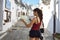 Back side of traveler girl searching right direction on map. Young woman visit Alberobello trulli in Apulia region, Italy