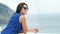 Back side view attractive fashion woman in sunglasses on balcony or terrace admiring seascape
