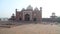 Back side view of Taj Mahal, with tourists through pation in front.